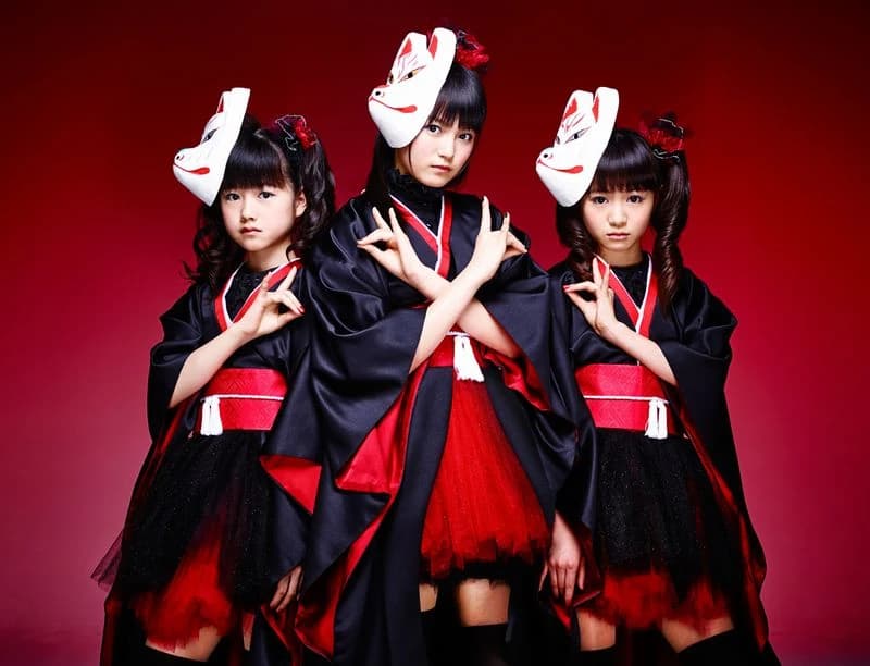 BABYMETAL durante una actuación en vivo de Megitsune con estética japonesa tradicional, máscaras de zorro y kimono estilizado