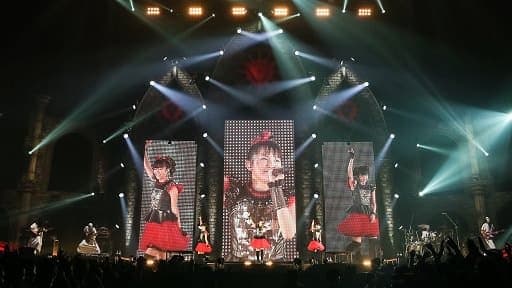 SU-METAL como frontwoman en gira internacional 2015, cantando en un escenario grande con la Kami Band detrás, mostrando su evolución vocal y escénica