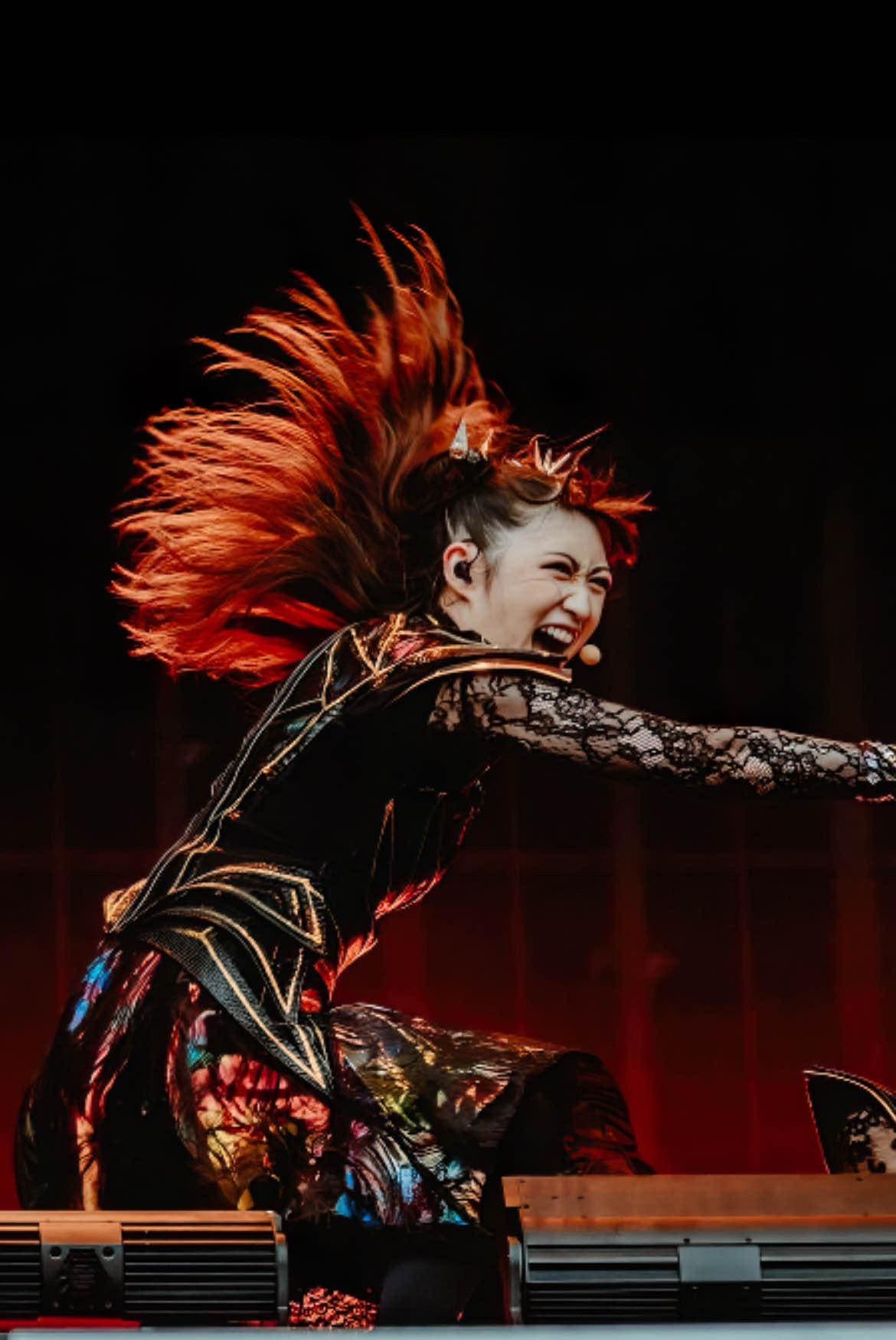 MOMOMETAL en su evolución de Avenger a miembro oficial de BABYMETAL, foto en el escenario mostrando su presencia escénica propia