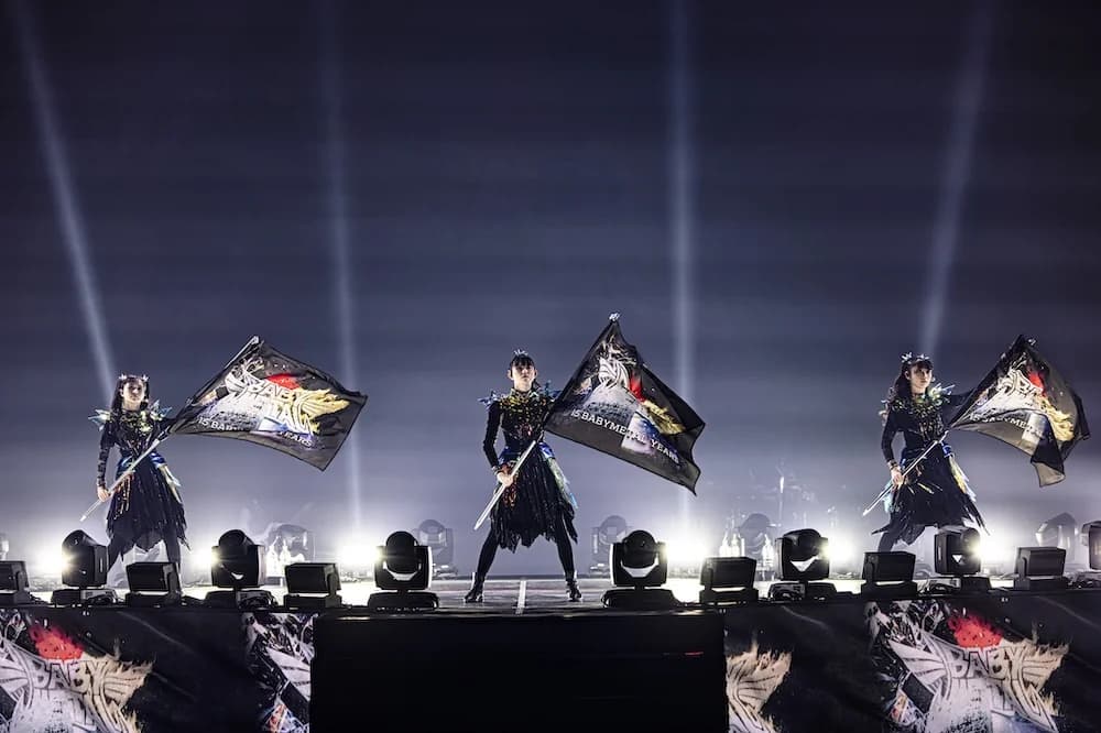 BABYMETAL en un gran escenario internacional representando su legado en la música pesada mundial, producción monumental con el trío en el centro